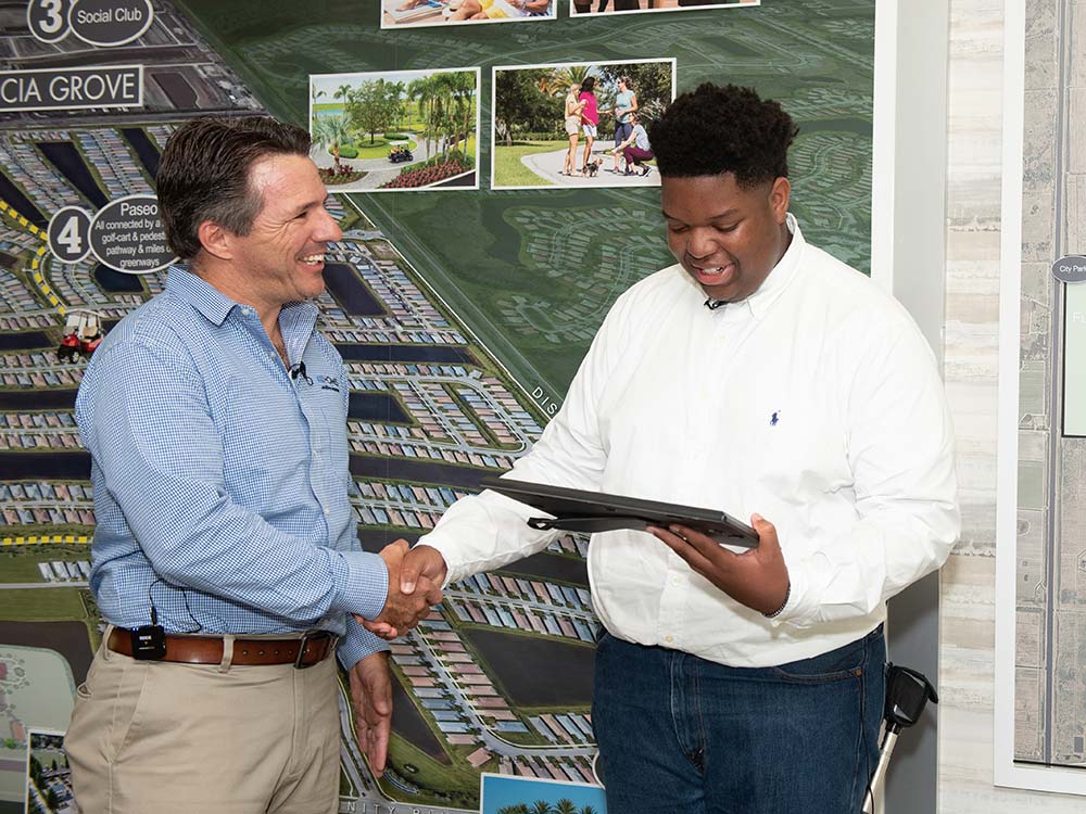 Justus Jones receives the GL Homes Inaugural College Scholarship for Engineering from Mike Fogarty.