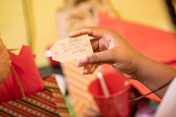 Boys & Girls Clubs of Lee County members write gift tags at GL Homes Holiday event.