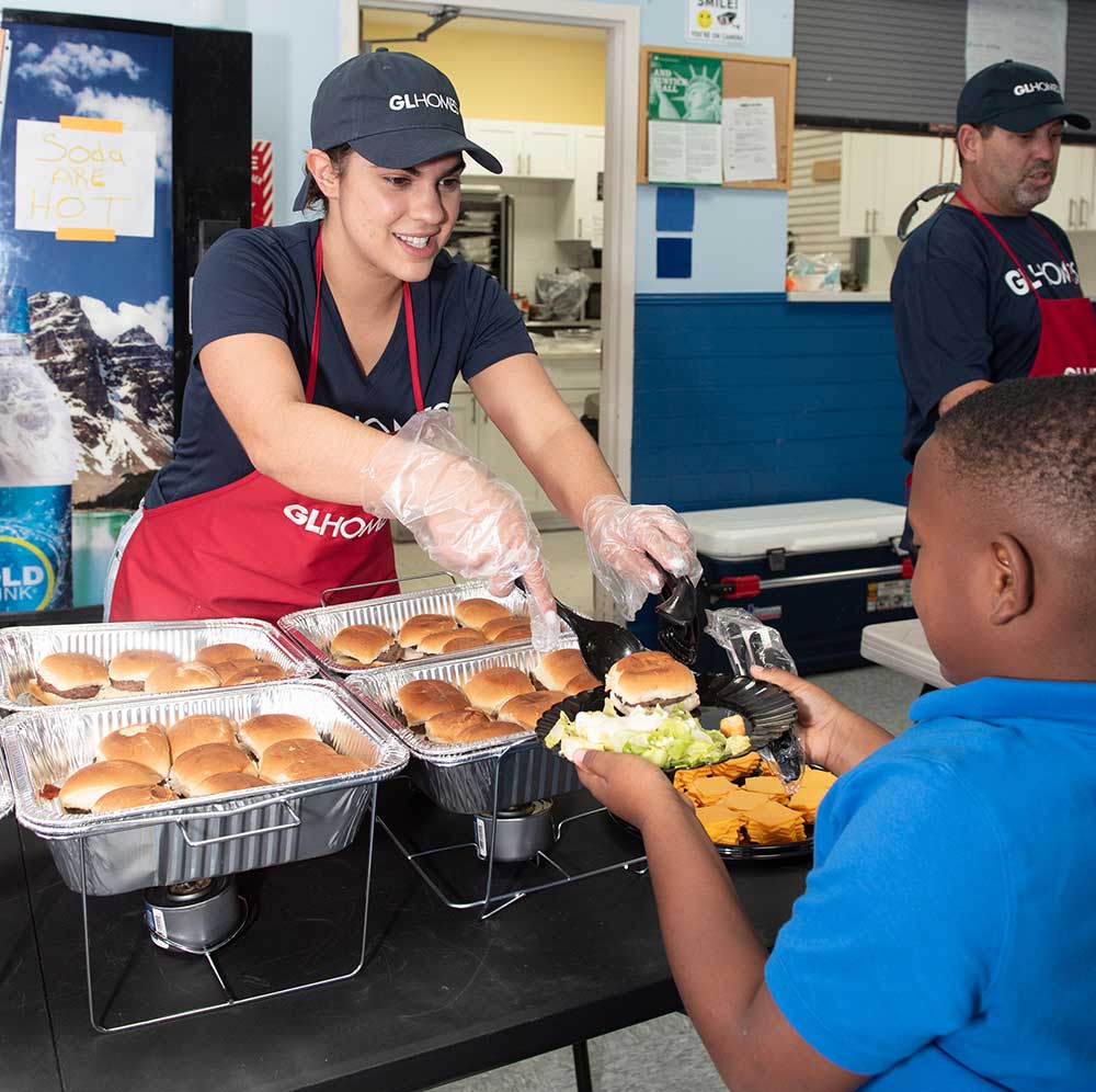 Employees of GL Homes volunteer to help the kitchen staff of Boys & Girls Clubs of Palm Beach County, Florida.