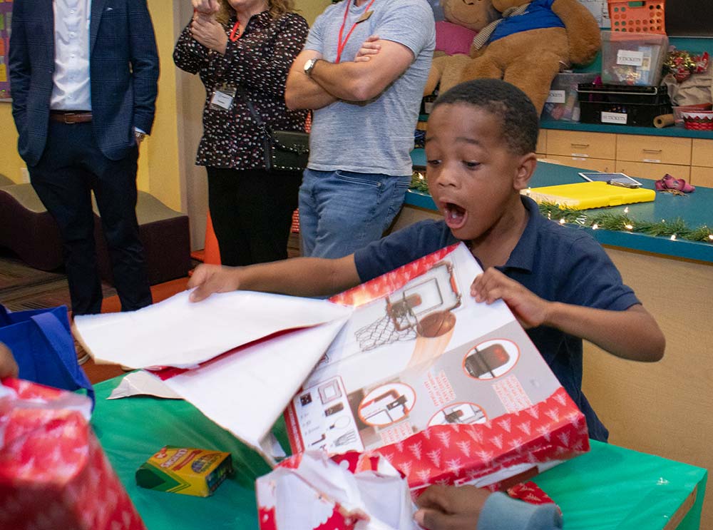 A child from Boys & Girls Clubs of Lee County opens a gift from GL Homes.